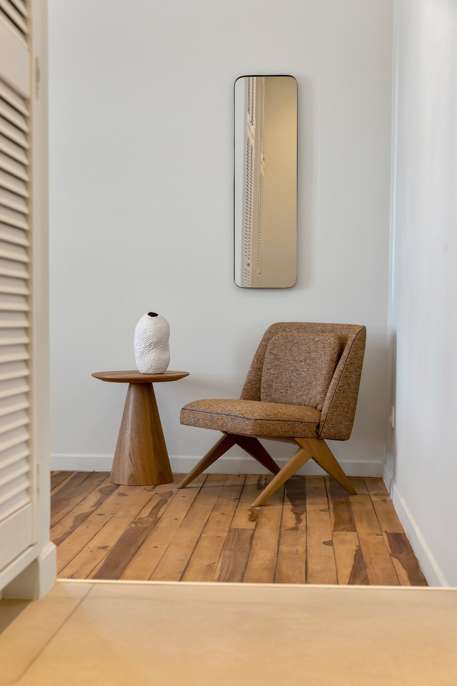 Chair, side table and mirror in a quiet corner