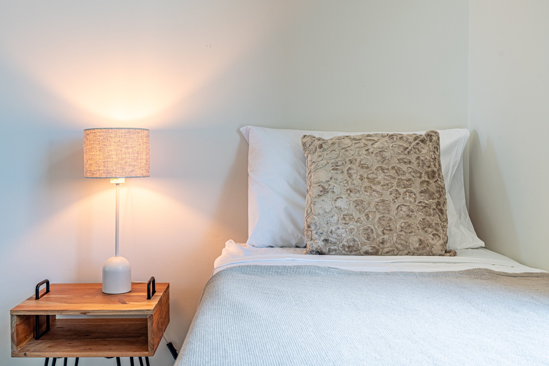 Bed and bedside lamp styled with natural textures