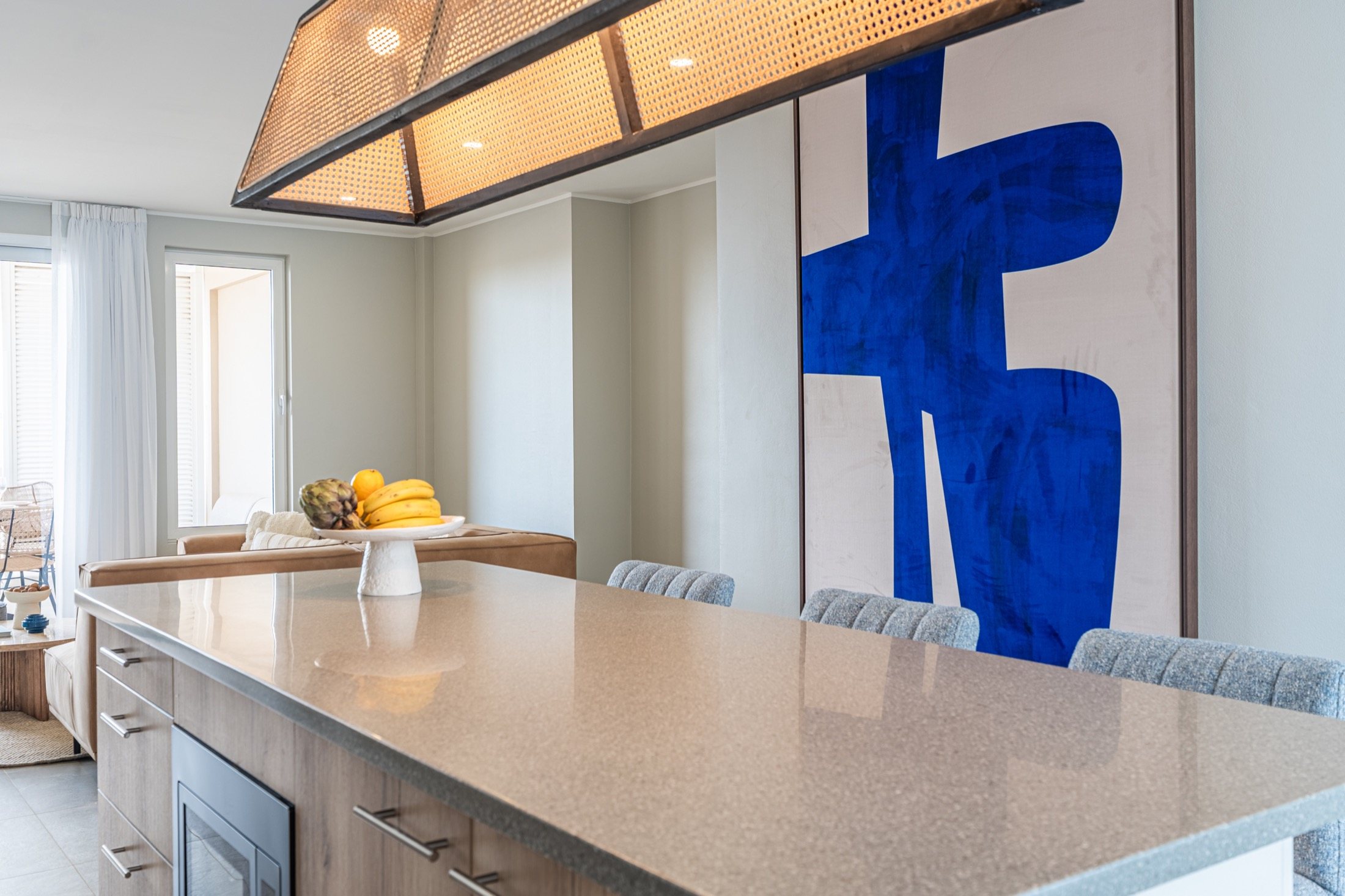 Kitchen island beneath a large blue artwork at Nikiboko Suit