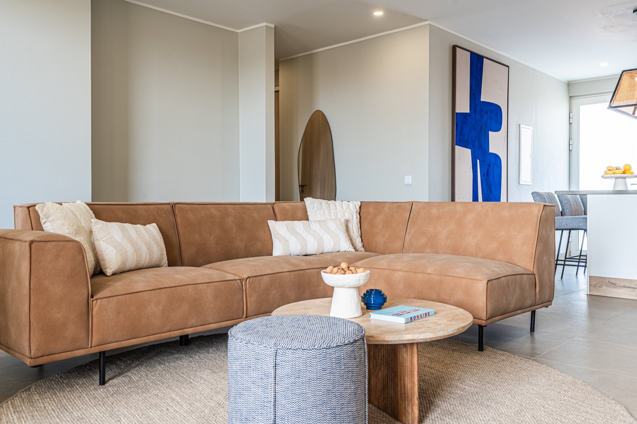 Living room with a leather sofa and poufs at Nikiboko Suit